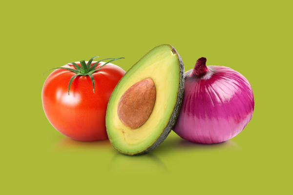 Tomato, avocado, and red onion on a green background