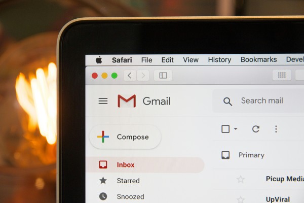 A laptop is open and showing the inbox of the Gmail email application